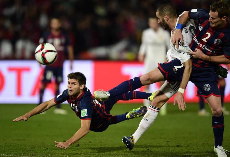 Real Madrid’s French forward Karim Benzema (2nd from R) vies for the ball against San Lorenzo’s defenders Walter Kannemann (L) and Mauro Cetto during their FIFA Club World Cup final football match at the Marrakesh stadium in the Moroccan city of Marrakesh on December 20, 2014. AFP PHOTO / JAVIER SORIANO