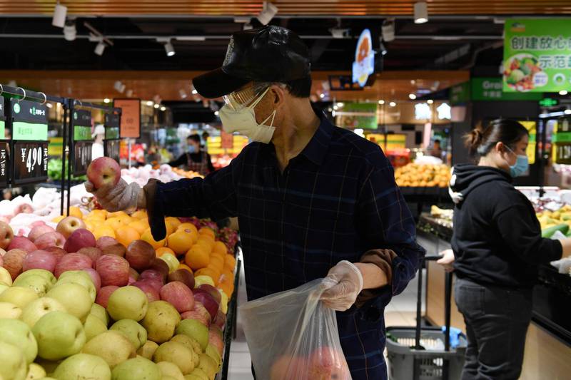 A man selects apples inside a supermarket in Wuhan on March 26, 2020. Reuters