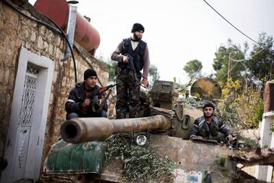Kurdish opposition fighters occupy a tank stolen from the Syrian Army, in Fafeen village, north of Aleppo.