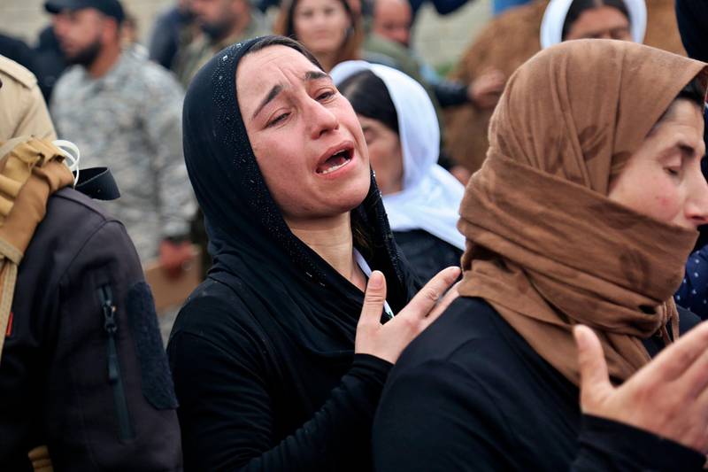 In this Friday, March 15, 2019 picture, Iraqi Yazidi women mourn during exhumation process of a mass grave in Iraq's northwestern region of Sinjar. The Iraqi government with U.N. support has started the exhumation process of the mass graves in Iraq's northwestern region of Sinjar.  (AP Photo/Farid Abdulwahed)