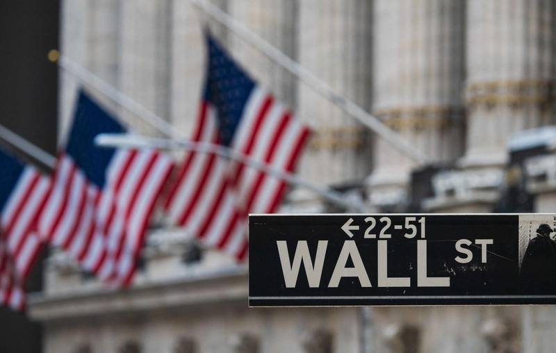 (FILES) In this file photo taken on March 23, 2021, a Wall St sign hangs at the New York Stock Exchange (NYSE) at Wall Street in New York City. Wall Street edged further towards normalcy on May 4, 2021 as the New York Stock Exchange (NYSE) withdrew some of its toughest Covid-19 restrictions and Goldman Sachs set a date for in-office work to resume. / AFP / Angela Weiss

