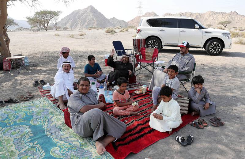 RAS AL KHAIMAH , UNITED ARAB EMIRATES , DEC 02  – 2017 :- Ali Al Hamri ( 60 years old right side in cap ) from Abu Dhabi spending time with his family and friends near Jebel Jais on the National Day in Ras Al Khaimah. (Pawan Singh / The National) Story by Anna Zacharias