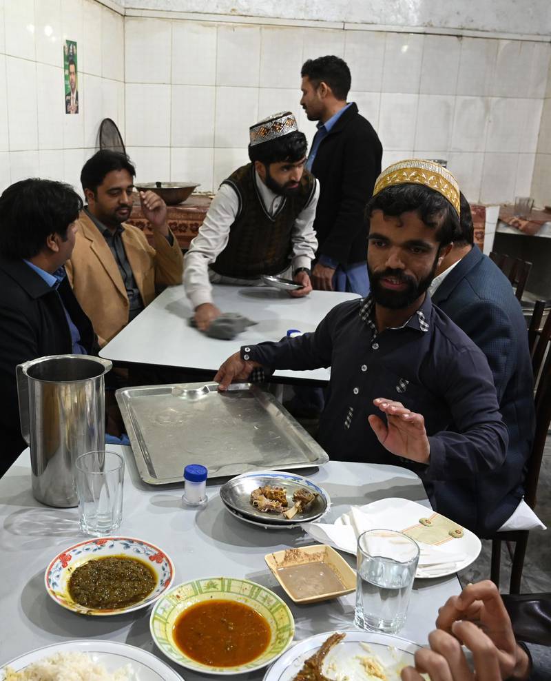 Rozi Khan serves food to customers at Dilbar Hotel in Rawalpindi. AFP