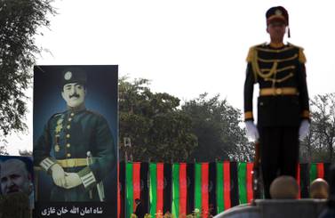 An Afghanistan guard of honour officer stands next to the billboard of King Amanullah Khan, who led Afghanistan to independence. EPA