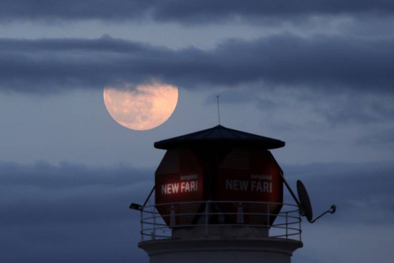 A pink supermoon is pictured near a lighthouse in Tirana, Albania. Reuters