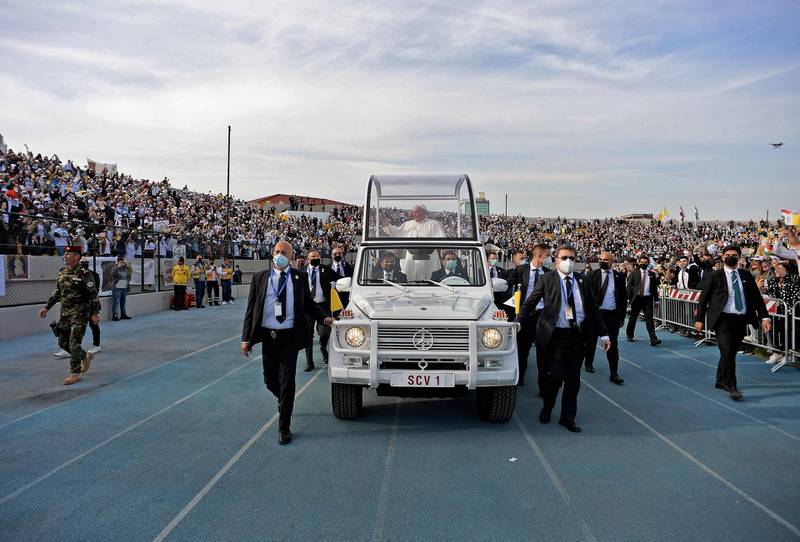 Pope Francis blessing people as he arrives in the popemobile vehicle at the Franso Hariri Stadium. AFP