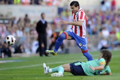 Atletico Madrid's Jose Antonio Reyes evades the tackle of Barcelona's Carles Puyol.