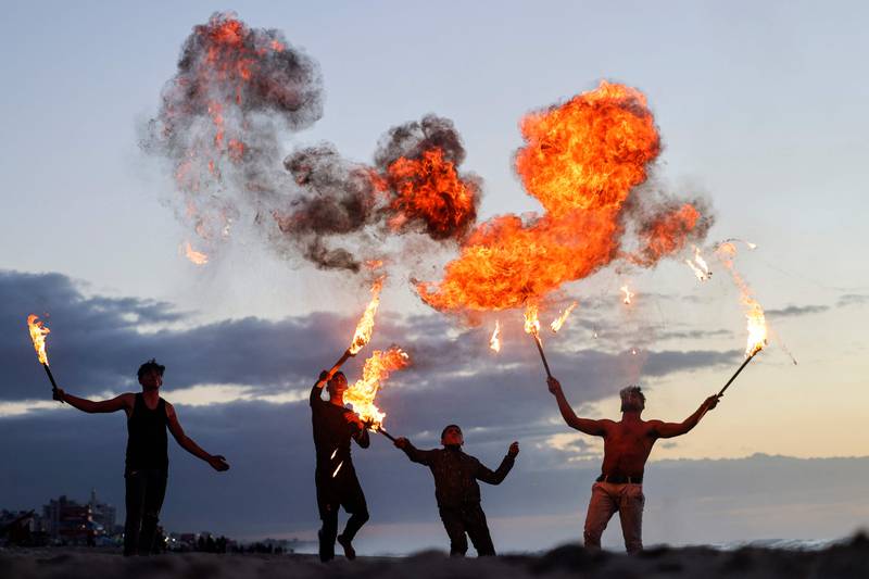 Palestinian youth show their fire breathing skills along the beach in Gaza city.