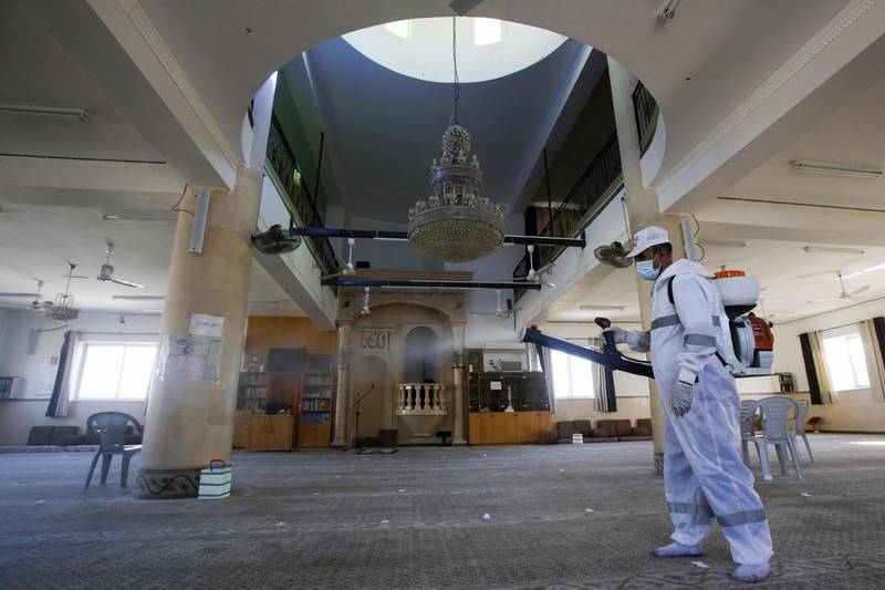 A Palestinian employee from Beit Sahur municipality disinfects a mosque after a coronavirus case from the village of Dar Salah, east of the west bank city of Bethlehem, was discovered among the prayers the previous day.  AFP