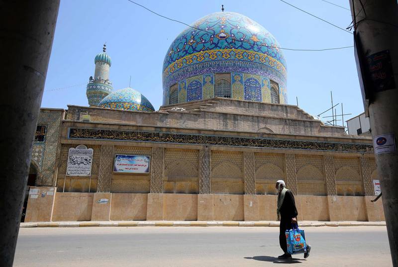 An Iraqi man walks past the closed Haydar-Khana mosque in the capital Baghdad, during the novel coronavirus pandemic crisis that urged authorities to shut down social gathering places in a bid to slow its spread among the population.   AFP
