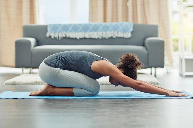 Shot of an attractive young woman practicing yoga at home