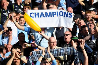 Manchester City fan holds up a banner as they celebrate winning the Premier League title. Reuters