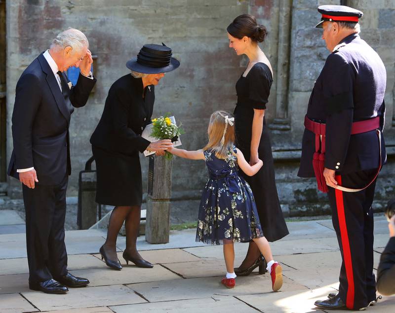King Charles and Camilla receive flowers after attending the service at St Llandaff Cathedral. AFP