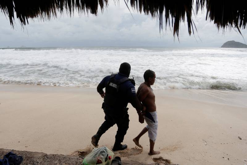 A man is detained by a police officer for refusing to leave a closed beach as Tropical Storm Pamela approaches Mazatlan. Reuters