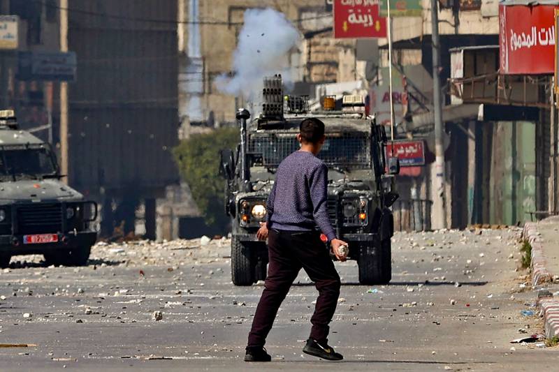 A Palestinian confronts an Israeli military vehicle during a raid in the West Bank city of Nablus on February 22. AFP
