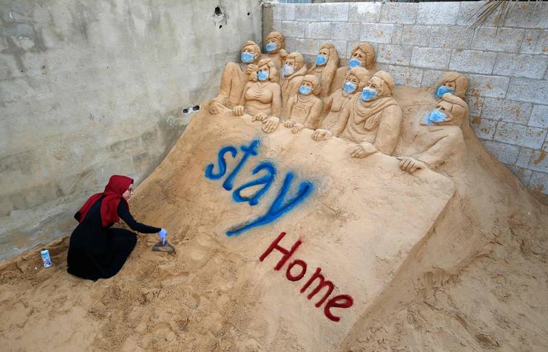 Palestinian artist Rana al-Ramlawi works on a sand sculpture in front of her home in Gaza City during the novel coronavirus pandemic crisis. AFP