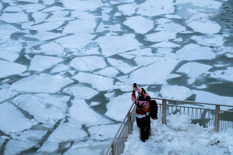 A pedestrian stops to take a photo by Chicago River, as the bitter cold phenomenon called the polar vortex has descended on much of the central and eastern United States. Reuters