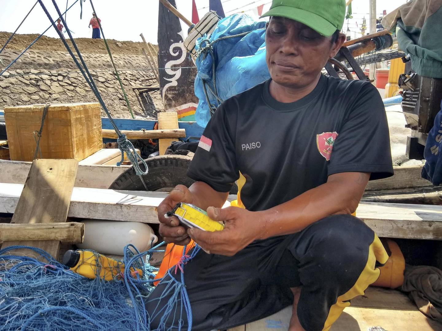 Pak Paiso, an artisanal fisherman in Muncar, Indonesia, with the Pisces device. Courtesy SafetyNet Technologies