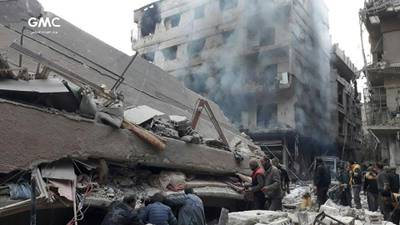 Syrians search for victims under the rubble of a building destroyed by Syrian government forces airstrikes. Ghouta Media Center via AP