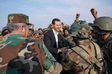 TOPSHOT - A handout picture released by the official Facebook page for the Syrian Presidency on October 22, 2019, shows Syrian soldiers cheering President Bashar al-Assad during his visit to al-Habit on the southern edges of the Idlib province. Syrian President Bashar al-Assad visited government troops on the front line with jihadists in Idlib, his first visit to the northwestern province since the start of the conflict. - RESTRICTED TO EDITORIAL USE - MANDATORY CREDIT "AFP PHOTO / Syrian Presidency Facebook page " - NO MARKETING NO ADVERTISING CAMPAIGNS - DISTRIBUTED AS A SERVICE TO CLIENTS / AFP / Syrian Presidency Facebook page / - / RESTRICTED TO EDITORIAL USE - MANDATORY CREDIT "AFP PHOTO / Syrian Presidency Facebook page " - NO MARKETING NO ADVERTISING CAMPAIGNS - DISTRIBUTED AS A SERVICE TO CLIENTS