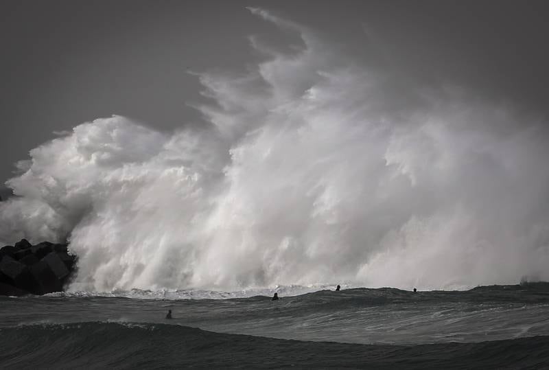 Surfers try to catch big waves at Zurriola's beach in San Sebastian, 15 March 2022.  Spanish State weather agency AEMET forecasts cloudy skies with strong winds for the next days.   EPA / Javier Etxezarreta