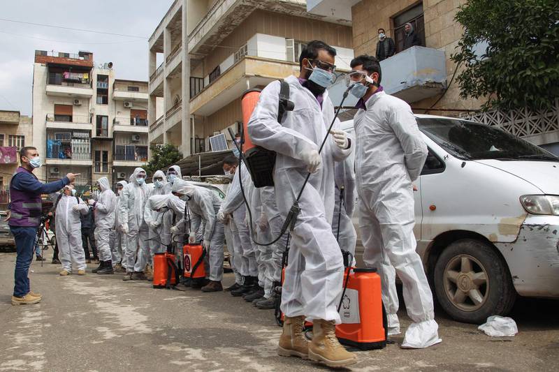 Members of the Syrian Violet NGO prepare to disinfect the Ibn Sina Hospital in Idlib on March 19, 2020. AFP
