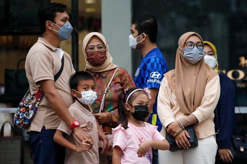 A family wear face masks in the Malaysian capital. Photo: EPA