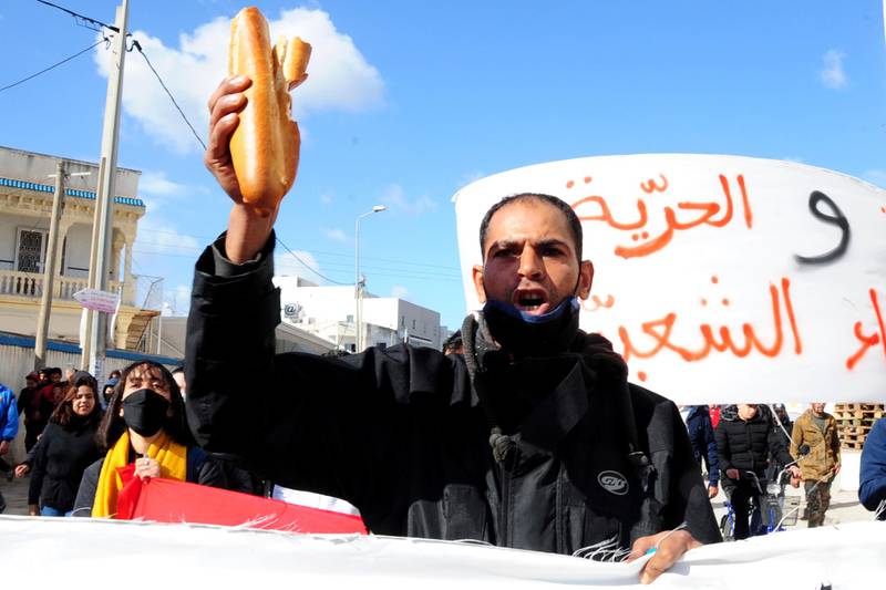 A protester shouts and holds bread during demonstration in Tunis. AP