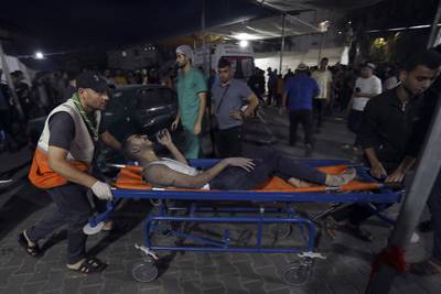 A wounded Palestinian is taken into Al Shifa hospital after Israeli air strikes on Gaza City. AP