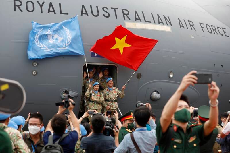 Vietnamese forces taking part in the UN peacekeeping mission in South Sudan wave flags in front of a Royal Australian Air Force aircraft during a departure ceremony, in Hanoi. EPA