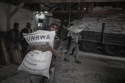 epa06988519 (FILE) A Palestinian refugee carries a sack with flour at the United Nation food distribution center in al Shateaa refugee camp in the northern Gaza city, 15 January 2018 (reissued 31 August 2018).  According to media reports on 31 August 2018, the United States has ended all funding to the United Nations Relief and Works Agency for Palestine Refugees in the Near East (UNRWA). 'The administration has carefully reviewed the issue and determined that the United States will not make additional contributions to UNRWA' according to a statement by the US State Department.  EPA/MOHAMMED SABER