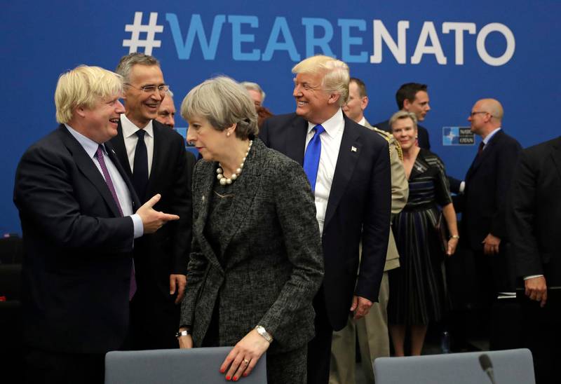 FILE - In this May 25, 2017, file photo, U.S. President Donald Trump jokes with British Foreign Minister Boris Johnson as British Prime Minister Theresa May walks past during a working dinner meeting at the NATO headquarters during a NATO summit of heads of state and government in Brussels. Threatening to upend generations of global order, Trumpâ€™s week-long European trip will test the strained bonds with some of the United Statesâ€™ closest allies before putting him face-to-face with the leader of the country whose electoral interference helped put him in office.  (AP Photo/Matt Dunham, Pool)