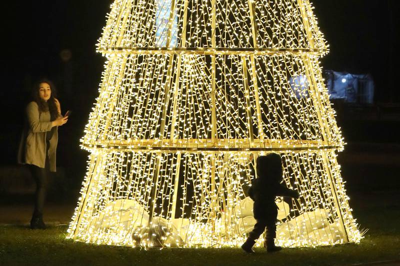 A child plays around a Christmas tree in the Syrian capital, Damascus, on December 22. AFP