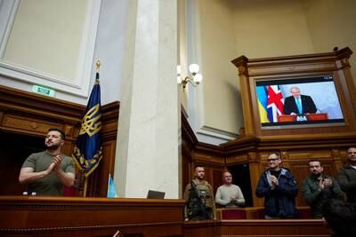 President Volodymyr Zelenskiy claps as British Prime Minister Boris Johnson addresses the Ukrainian Parliament in Kyiv via videolink. Reuters
