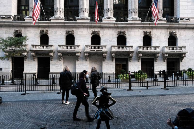 The 'Fearless Girl' sculpture is seen outside the New York Stock Exchange building. Wall Street stocks finished strong on Friday as investors pinned their hopes on lower interest rate rises from the US Federal Reserve. AFP