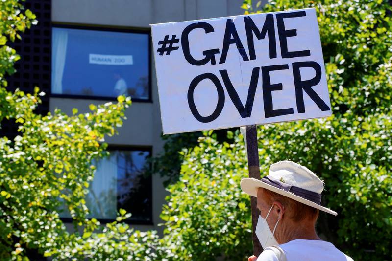 A pro-refugee protestor holds a 'game over' sign outside the Park Hotel in Melbourne, where Novak Djokovic is staying during his battle to be admitted for the Australian Open. Reuters