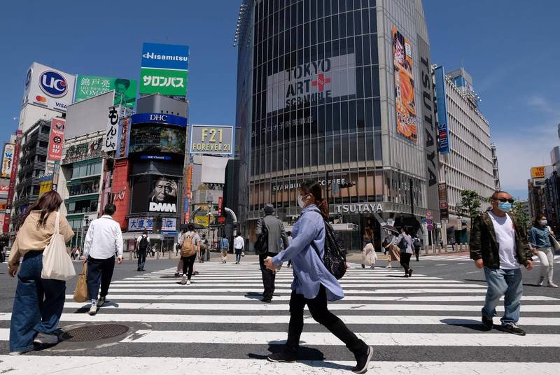 People wearing face masks amid concerns over the spread of the COVID-19 coronavirus cross the Shibuya crossing in Tokyo on May 17, 2020.   / AFP / Kazuhiro NOGI
