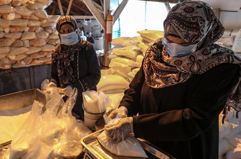 Palestinian workers at the United Nation Relief and Works Agency prepare rations for refugee families at Al Shatea refugee camp, Gaza City. Mohammed Saber / EPA
