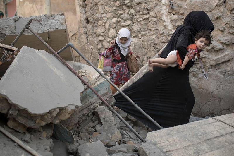 Civilians flee through a destroyed alley as Iraqi Special Forces continue their advance against Islamic State militants in the Old City of Mosul, Iraq, Sunday, July 2, 2017. (AP Photo/Felipe Dana)
