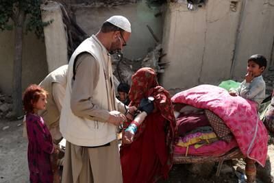 An Afghan woman is treated by a doctor. Reuters