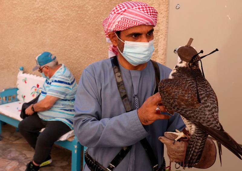 A masked falconer entertains tourists at Dubai's historic Al Fahidi neighbourhood. AFP