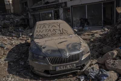 A message scrawled on a car covered in dust from collapsed buildings in Antakya, Turkey. AP