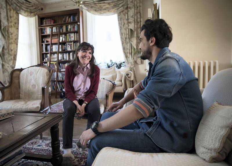 LONDON 11th April 2019. Syrian refugee Basil talks to his host Karina (only first names agreed to be used)  in the living room of  her house in west London. Stephen Lock for the National . NB: The subject did not want his full face to be photographed, happy with a profile.