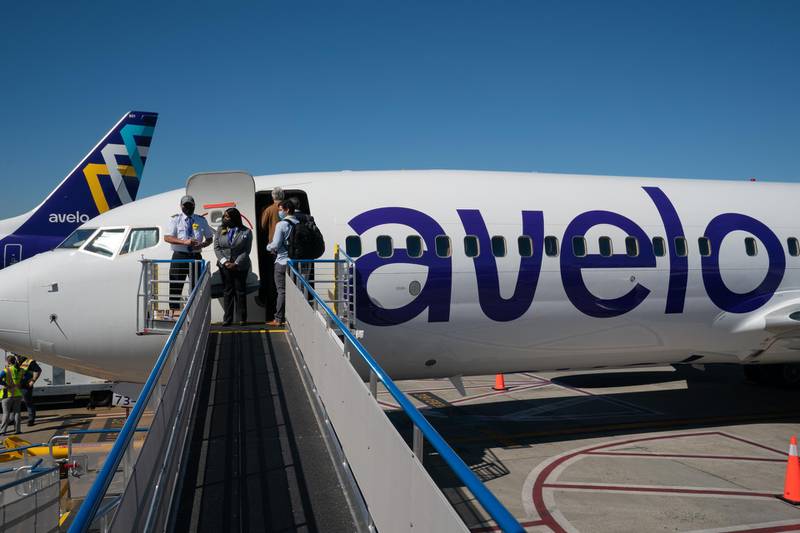 Cabin crew wait as passengers board a Boeing Co. 737-800 aircraft operated by Avelo Airlines ahead of the airline's inaugural flight. Bloomberg