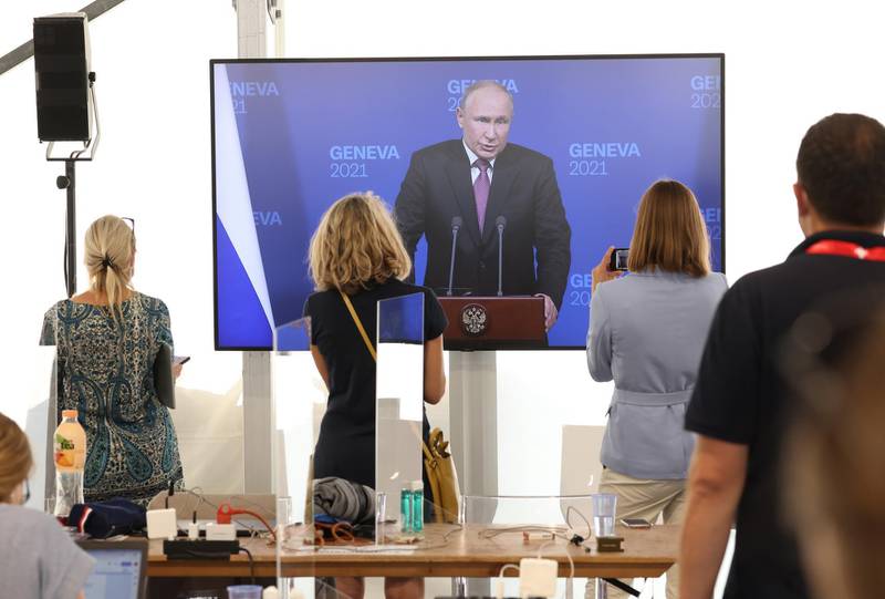 Journalists watch a live broadcast of Mr Putin's address. Getty Images