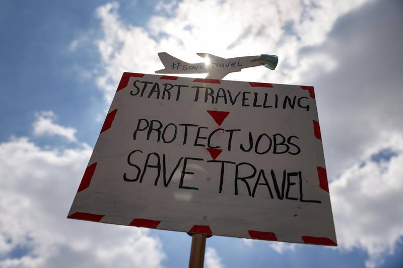 A placard that reads "Start Travelling, Protect Jobs, Save Travel". Bloomberg