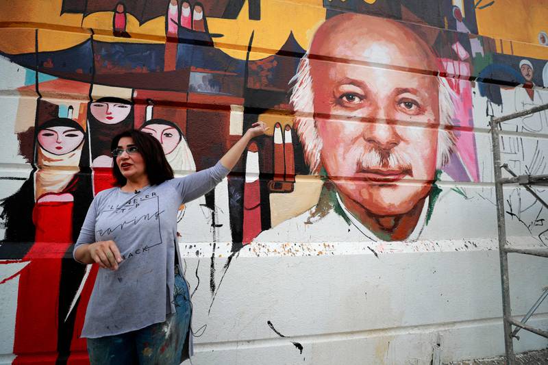 Iraqi artist Wijdan al-Majed draws a mural depicting Iraqi poet Muthaffar Al Nawab in Baghdad. AFP