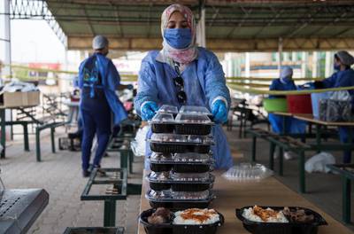 epa08424491 Volunteers wearing face masks pack meals for poor people during the Muslims fasting month of Ramadan at 'LeBaladna' (for our country) charity organization, in Cairo, Egypt, 15 May 2020.  EPA-EFE/MOHAMED HOSSAM *** Local Caption *** 56088616