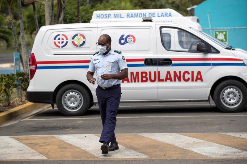 A masked air force officer arrives after driving an ambulance to the Ramon de Lara military hospital in Santo Domingo, Dominican Republic.  EPA