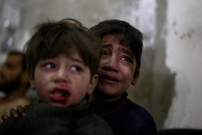 Children react as they wait for treatment at a makeshift hospital following air strikes by forces loyal to President Bashar al-Assad in the rebel held area of Douma, Syria.  Abd Doumany / AFP